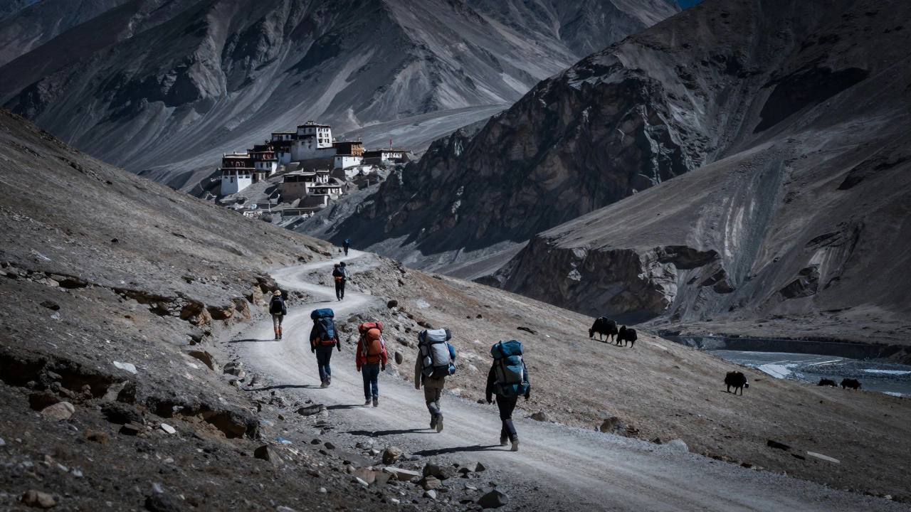 Group of trekkers crossing a high pass in Spiti Valley with monasteries and yaks in distance.