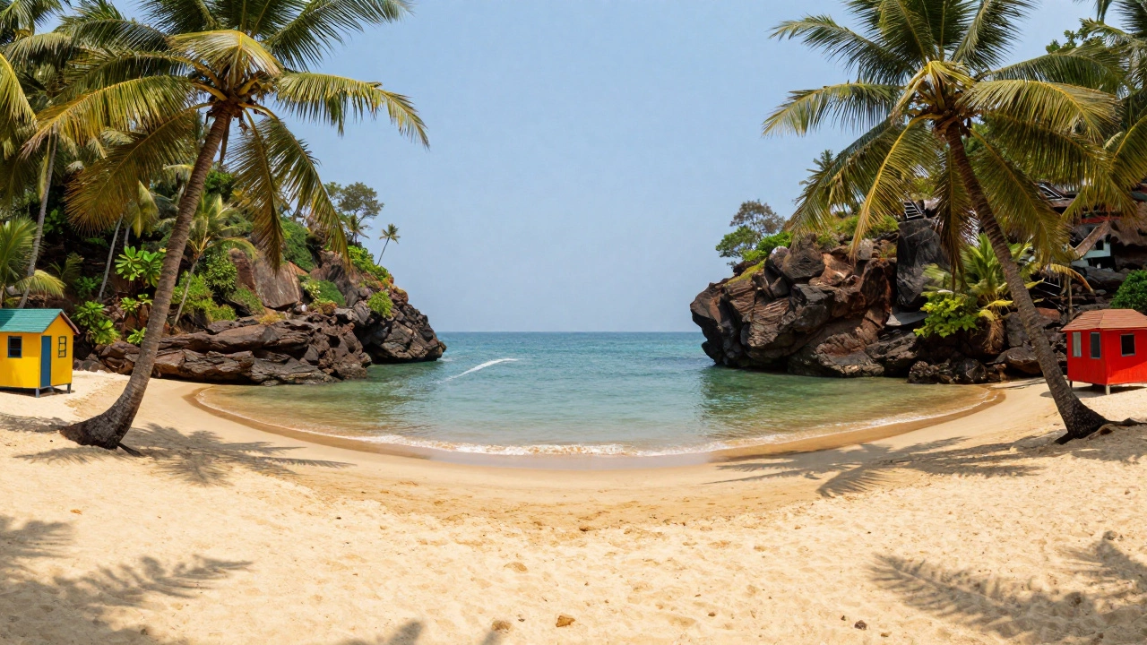 Symmetrical crescent bay of Palolem Beach with colorful huts and coconut palms